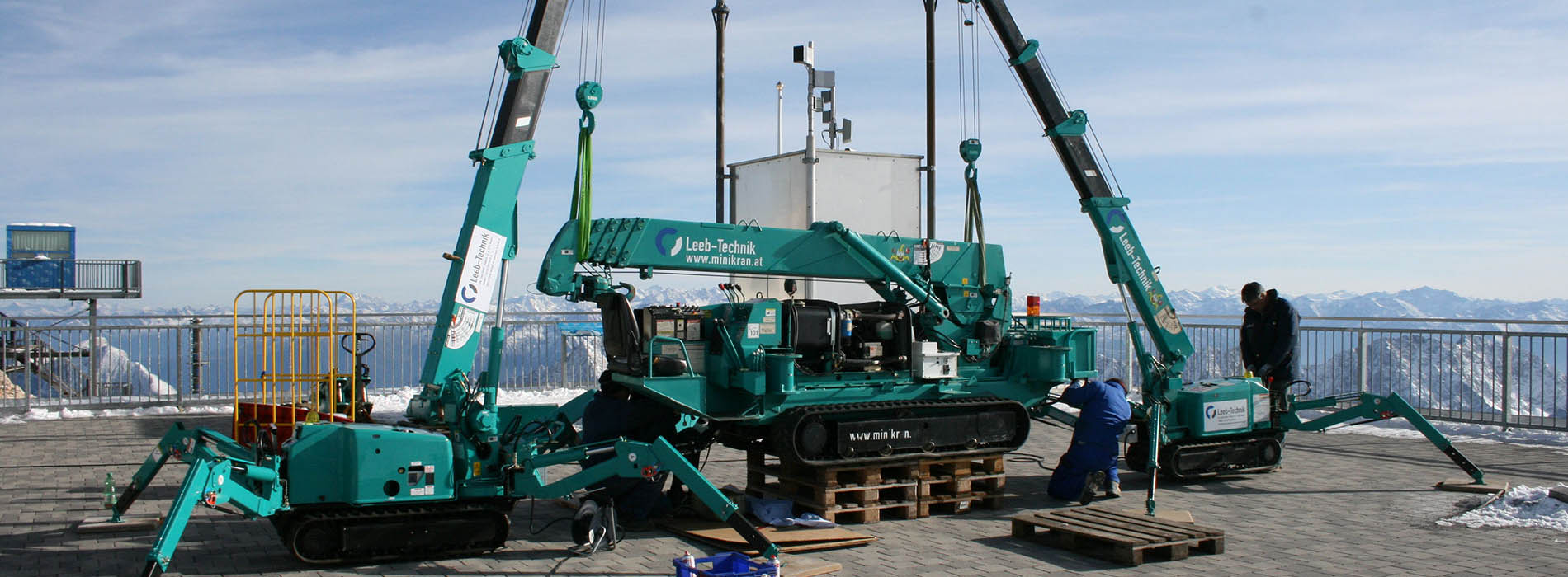 Mini-mini-grues MAEDA soulevant des machines sur un toit 
