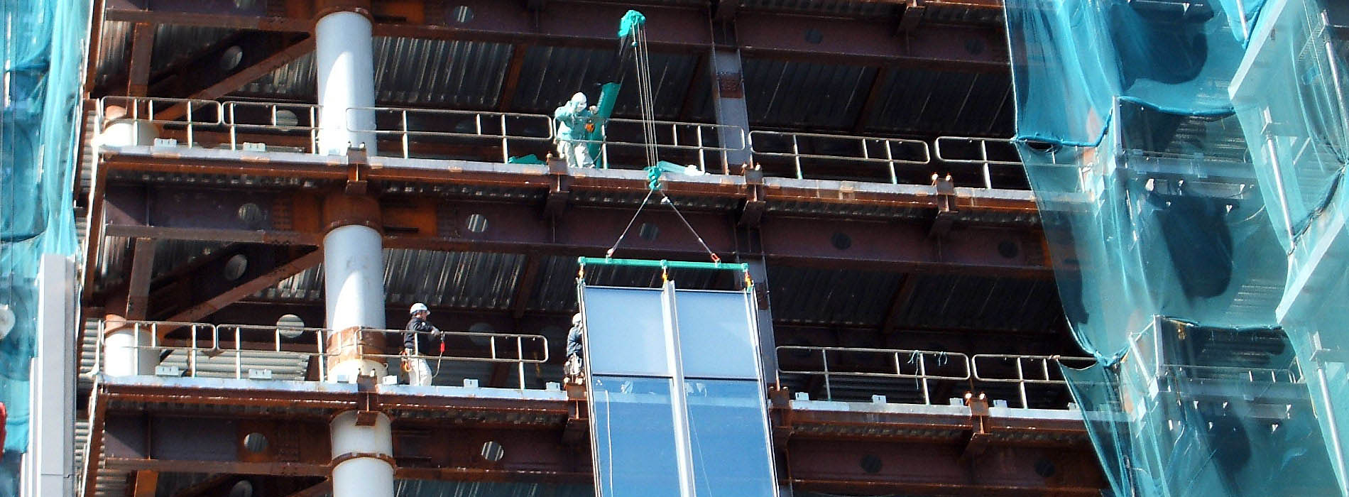 Mini-grue MAEDA levant un cadre de verre pour l'installation de murs-rideaux