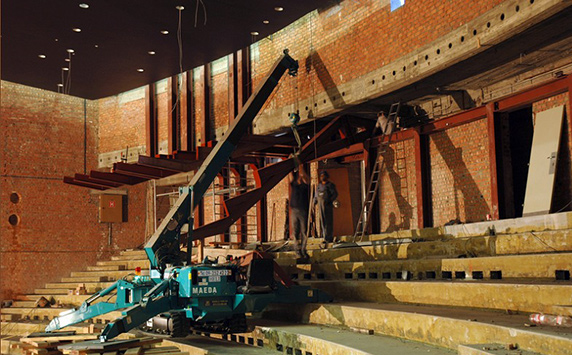 Mini-grue MAEDA levant dans une zone intérieure sur un sol irrégulier